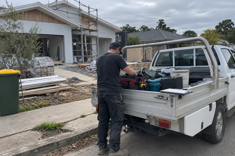 A tradesperson packing the tools into a ute at the end of the working day